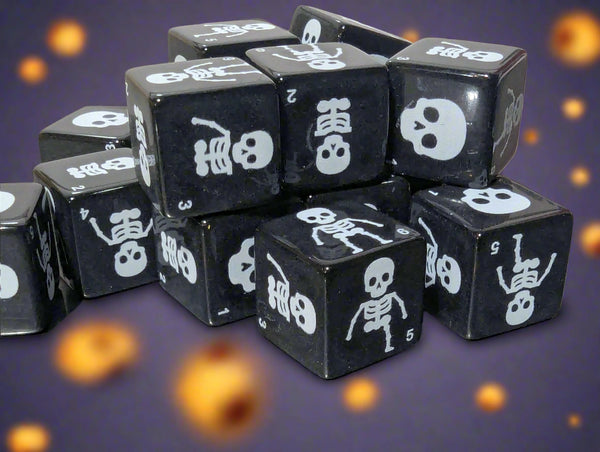 Black dice with skeleton and skull designs on a reflective surface
