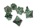 Set of green and silver polyhedral dice on a white surface