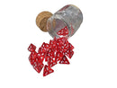Red dice with white numbers spilling out of a glass container on a metallic surface.